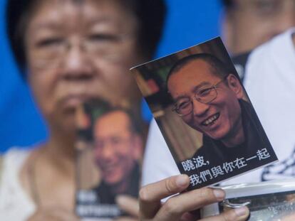 Un activista de la Alianza de Hong Kong de Apoyo a los Movimientos Democr&aacute;ticos Patri&oacute;ticos de China muestra una postal en apoyo al disidente chino Liu Xiaobo.