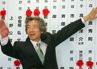 Junichiro Koizumi marca con rosas de papel los escaños ganados por su partido en el Senado.