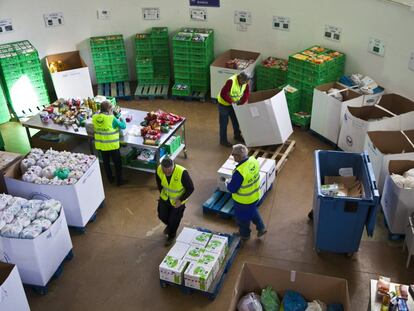 Varios voluntarios del Banco de Alimentos distribuyen las donaciones en un almacén.