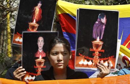 Una tibetana exiliada muestra imágenes de monjes budistas que se inmolaron en las protestas contra el Gobierno chino.