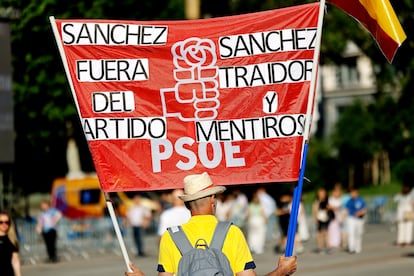 Un manifestante sujeta una pancarta contra el secretario general del PSOE y presidente del Gobierno, Pedro Sánchez, este domingo, en la plaza de España de Madrid.