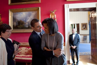Los Obama se abrazan ante la atenta mirada de la asistenta presidencial Valerie Jarrett (izquierda), en marzo de 2009.