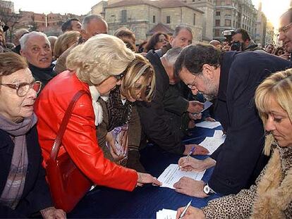 Mariano Rajoy firma en contra del nuevo Estatuto catalán durante un acto político en León.