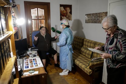 La doctora Pilar Kloppe atiende a Pedro Mesas, de 78 años, que se recupera en casa de neumonía pero ha dado negativo por covid-19. A la derecha, María Ángeles, esposa del paciente.