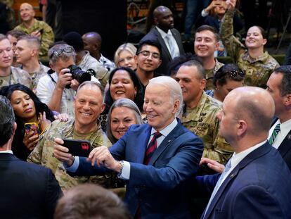 President Joe Biden takes a selfie during a visit to Fort Liberty, N.C.