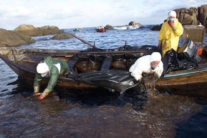 Percebeiros de Santa Mariña (A Coruña) recogen con las manos desde una barca el chapapote vertido por el petrolero Prestige el 19 de diciembre de 2002. 