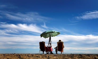Una pareja toma el sol en la playa de la Malvarrosa, en Valencia.