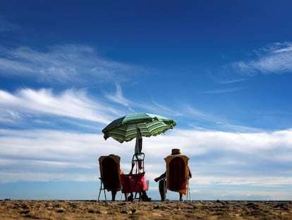 Una pareja toma el sol en la playa de la Malvarrosa, en Valencia.