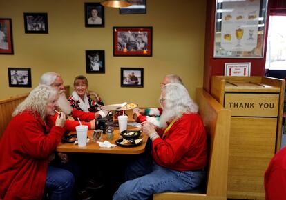 Santas y señoras Claus disfrutan de una pizza durante un descanso de clases, en Midland, Michigan, el 27 de octubre de 2016.