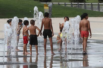 Un grupo de niños se refresca este martes en el parque madrileño de Juan Carlos I.