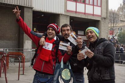 Tres aficionados rojiblancos muestran las entradas que han conseguido tras pasar la noche al raso en las inmediaciones de San Mamés