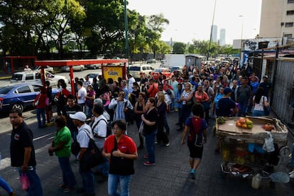 Um grupo de pessoas espera o ônibus em Caracas.