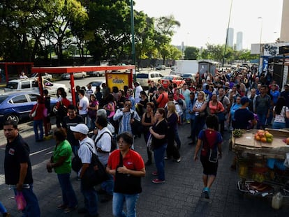 Un grupo de personas espera el autobús en Caracas.