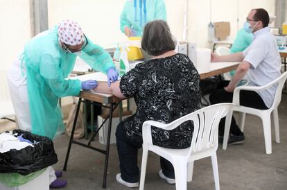 Varios sanitarios con dos pacientes durante una de las jornadas del test serológico masivo de coronavirus que el Ayuntamiento de Torrejón desplegó para los vecinos.