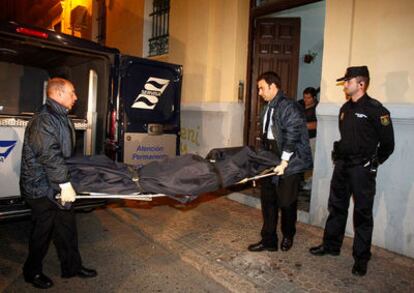 Los empleados de los servicios fúnebres trasladan el cuerpo de la mujer asesinada en Sevilla.