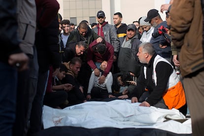 El hijo de uno de los palestinos de la familia Nassar, fallecido durante los ataques aéreos israelíes en el sur de Gaza, llora junto al cuerpo envuelto de su padre, frente al hospital Nasser de Jan Yunis, este miércoles.
