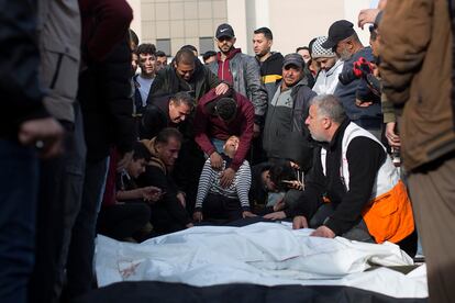 El hijo de uno de los palestinos de la familia Nassar, fallecido durante los ataques aéreos israelíes en el sur de Gaza, llora junto al cuerpo envuelto de su padre, frente al hospital Nasser de Jan Yunis, este miércoles.
