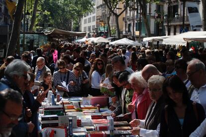 Molta gent mirant i remenant llibres. 