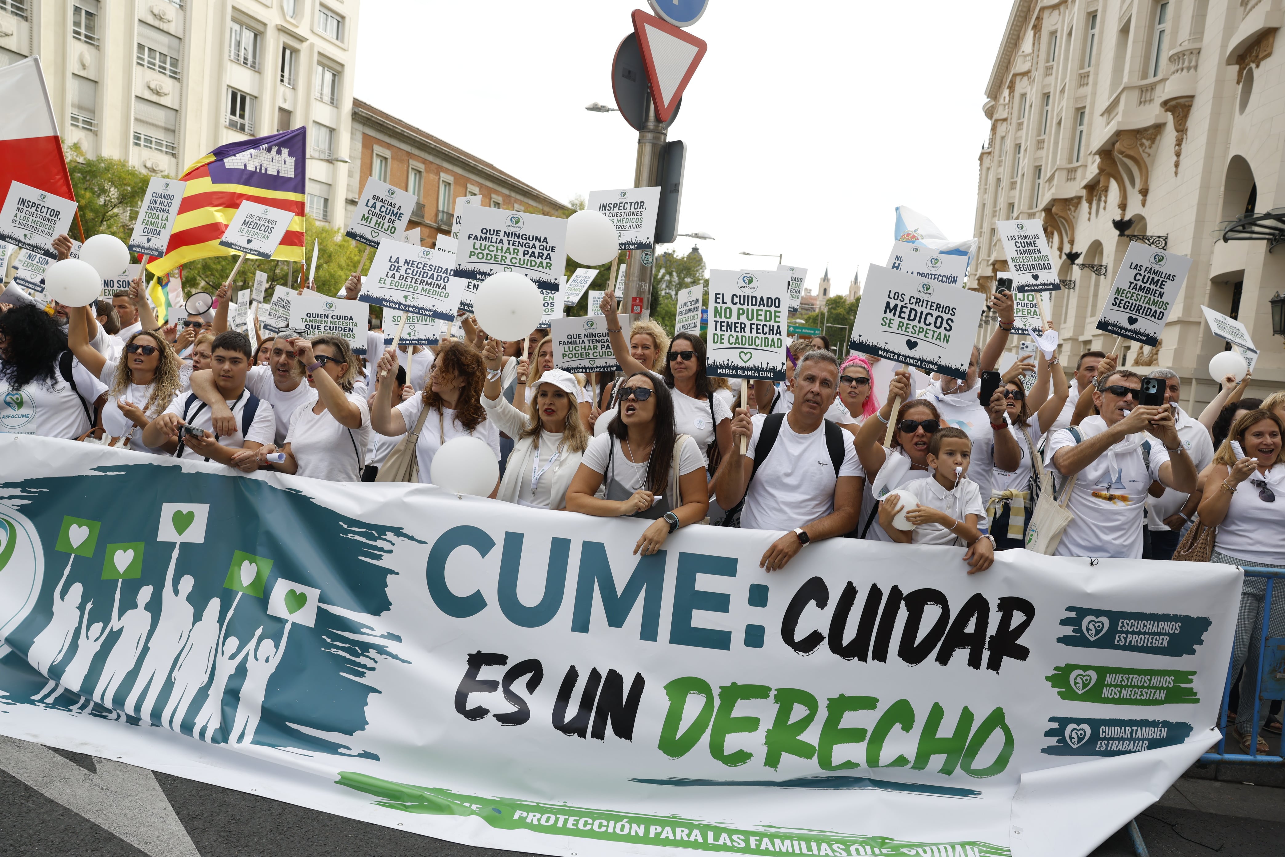 Las familias de los menores con enfermedades graves se concentran con pancartas y globos blancos para pedir una mejora de sus derechos.