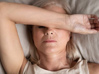 Closeup melancholic woman lying put hand on face feels unwell