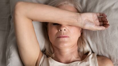 Closeup melancholic woman lying put hand on face feels unwell