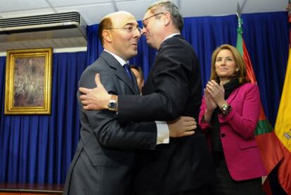 Gallardón (derecha) abraza a Carlos Urquijo en presencia de la presidenta del Parlamento vasco, Arantza Quiroga, ayer en Vitoria.