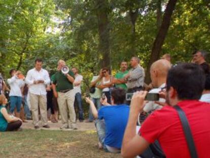 El Nobel Stiglitz, de verde y megáfono en mano, se dirige a la asamblea de los indignados en el parque de El Retiro.