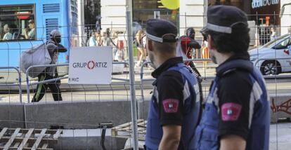 Dos policías municipales observan a dos manteros en la Gran Vía, este martes.