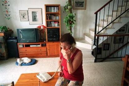 Una mujer habla por su teléfono fijo desde el salón de su casa en Barcelona.