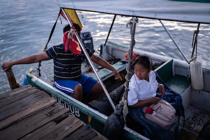 A student waits for her classmates on a boat to take them to school on the island of Gardi Sugdub.