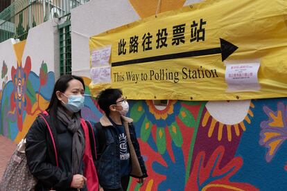 Una mujer acude a votar con su hijo en un centro electoral de Hong Kong, este domingo.