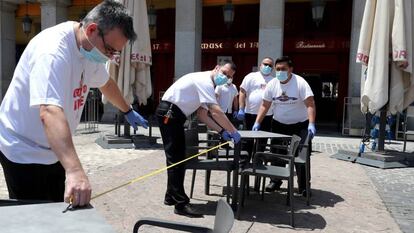 Montaje de una terraza en el Plaza Mayor de Madrid, este domingo.