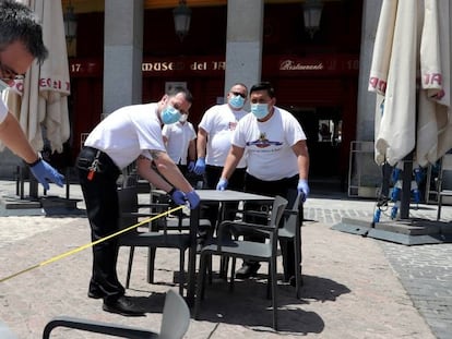 Montaje de una terraza en el Plaza Mayor de Madrid, este domingo.