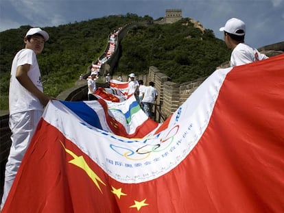 Voluntarios chinos sostienen una bandera formada con distintos escudos nacionales.