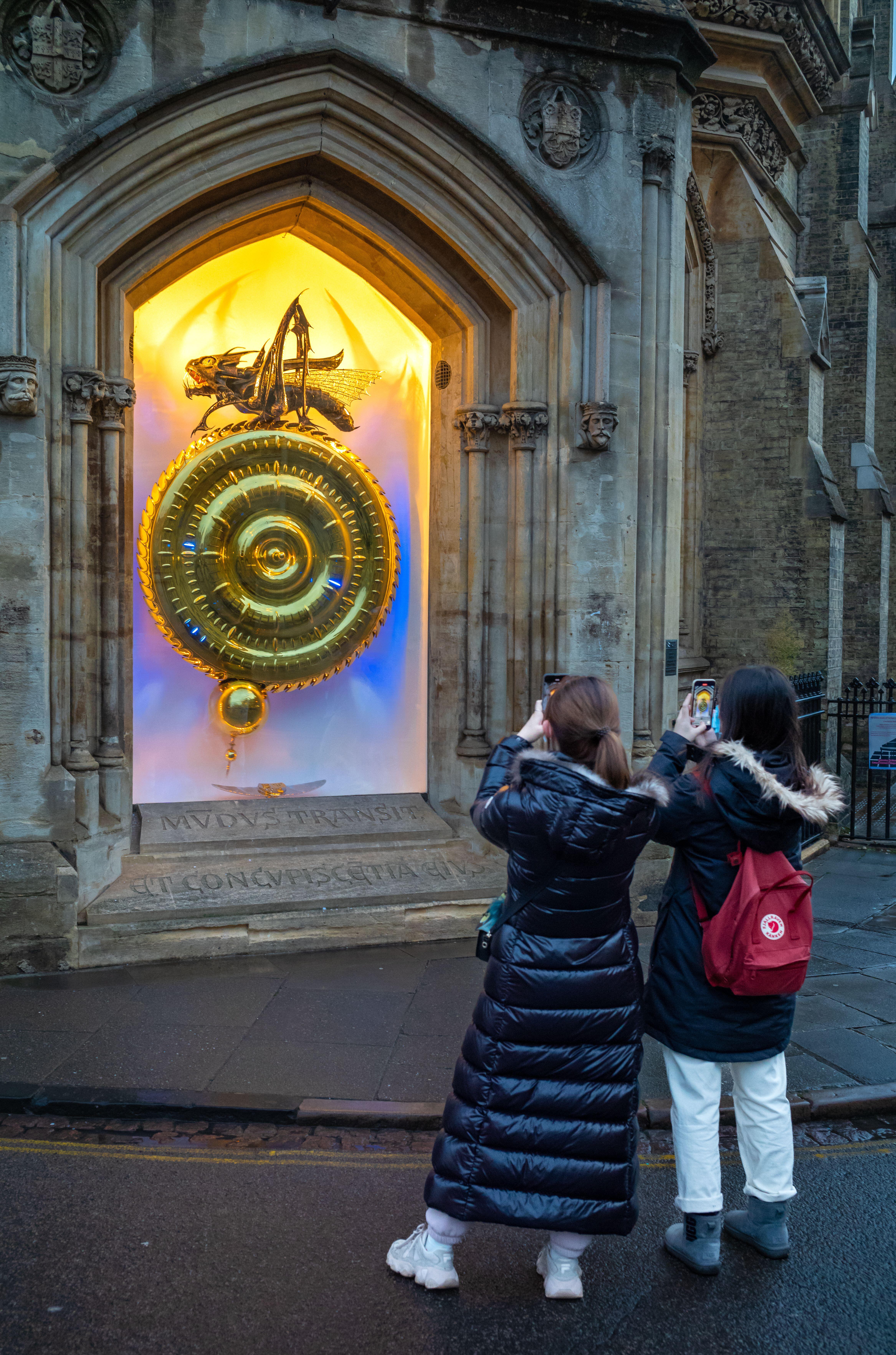 Dos estudiantes extranjeras sacan fotos a 'The Corpus Clock' en el Instituto del Corpus Christi, en Cambridge (Inglaterra). 