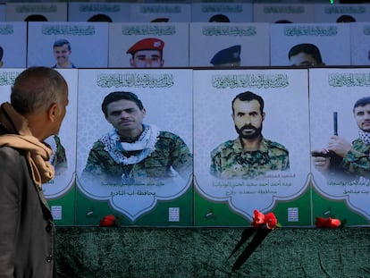A Yemeni stands in front of portraits of Houthi fighters, who were allegedly killed in the country's war, part of an exhibition during the Martyr Week anniversary in Sana'a, Yemen, December 07 2023.