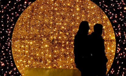 Dos personas pasean por una calle decorada con motivos navideños en el centro de Belgrado (Serbia), la noche del 28 de noviembre de 2018.