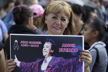Una mujer sostiene un póster de Juan Gabriel en México.