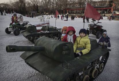 Varios niños se sientan en tanques de juguete en el segundo día del Año Nuevo Chino, en Pekín (China).