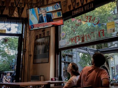 Clientes miran a Luis Caputo, ministro de Economía de Argentina, pronuncia un discurso en televisión sobre medidas económicas, en Buenos Aires, en diciembre de 2023.