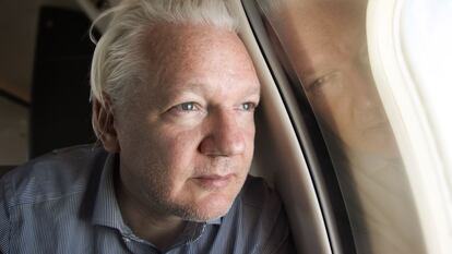 Julian Assange mira por la ventanilla del avión en los alrededores del aeropuerto de Bangkok, este martes.