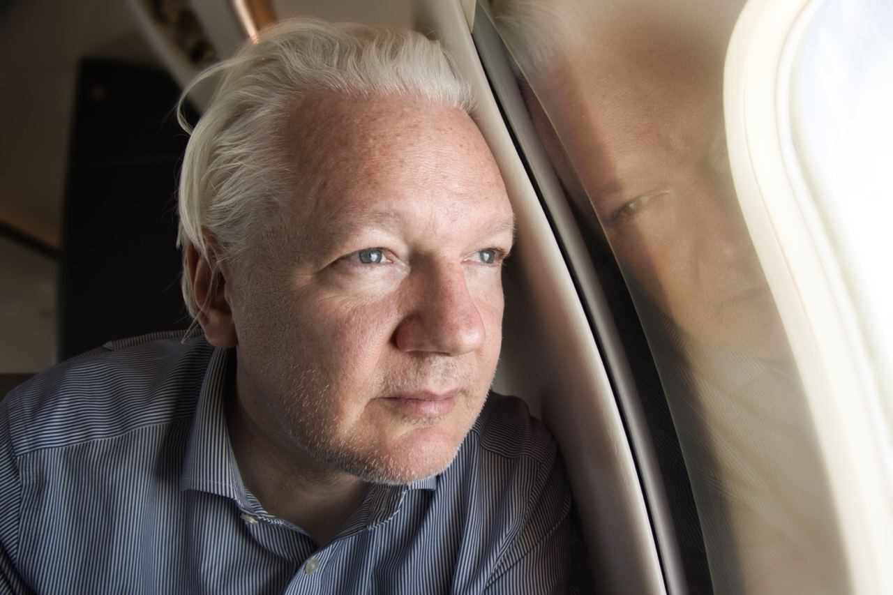 Julian Assange mira por la ventanilla del avión en los alrededores del  aeropuerto de Bangkok, este martes.