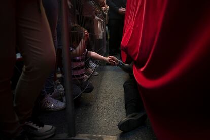Un niño sujeta la mano de un costalero durante la procesión de 'El Cristo de los Gitanos' en Granada, este Miércoles Santo. 
