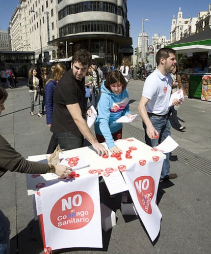 Varios miembros del PSM reparten propaganda contra el copago en el centro de Madrid.