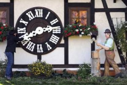 En la imagen de ayer, una mujer cambia la hora en el reloj de cuco más grande del mundo en Schonach (Alemania).