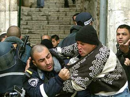 Un policía israelí forcejea con un palestino para impedirle la entrada a la mezquita de Al Aqsa, en el centro histórico de Jerusalén.