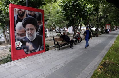 Una mujer camina junto a un cartel del fallecido presidente iraní Ebrahim Raisí, este martes en una calle de Teherán.