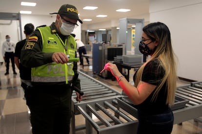 Un oficial de policía verifica la identificación de un pasajero en el aeropuerto Olaya Herrera en 2020 en Medellín, Colombia.