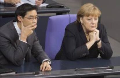 La canciller alemana, Angela Merkel (d), y el ministro alemán de Economía, Philipp Rösler, durante un debate en el "Bundestag" (Parlamento federal) en Berlín, Alemania, hoy.