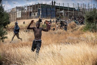 Migrantes subsaharianos corren nada más saltar la valla fronteriza de Melilla. 